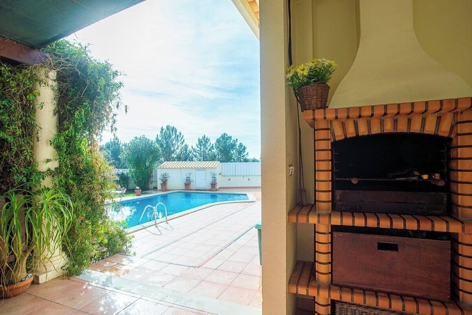 Rectangular swimming pool with blue loungers and parasols — Villa Alegre, holiday villa in Seixal