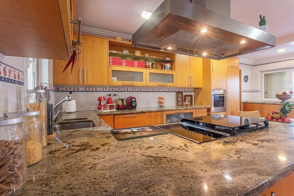 Modern kitchen with granite worktops and wooden cabinetry — Villa Alegre, holiday villa in Seixal