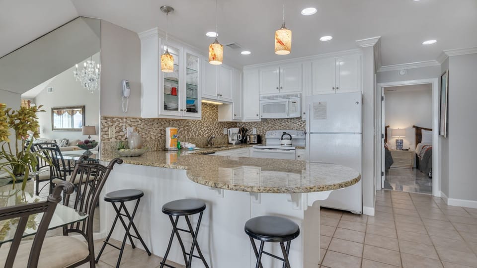 Enjoy the updated kitchen featuring a sleek countertop bar that offers additional seating—perfect for casual meals or gathering with family.