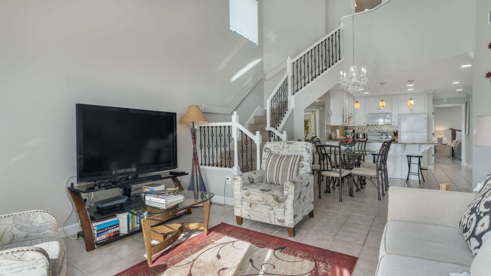 This bright, open living space features soaring ceilings and a comfortable layout that flows effortlessly into the dining area and kitchen.