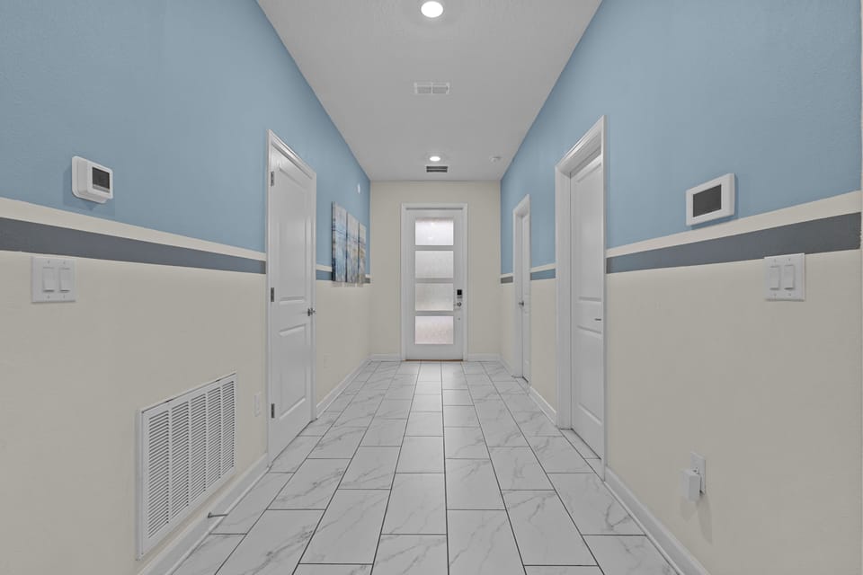 Step into your welcoming hallway with soothing blue and cream tones, marble-look flooring, and individual climate control for your comfort.