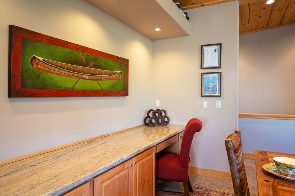 Spacious granite countertop desk area located on back wall of dining area.
