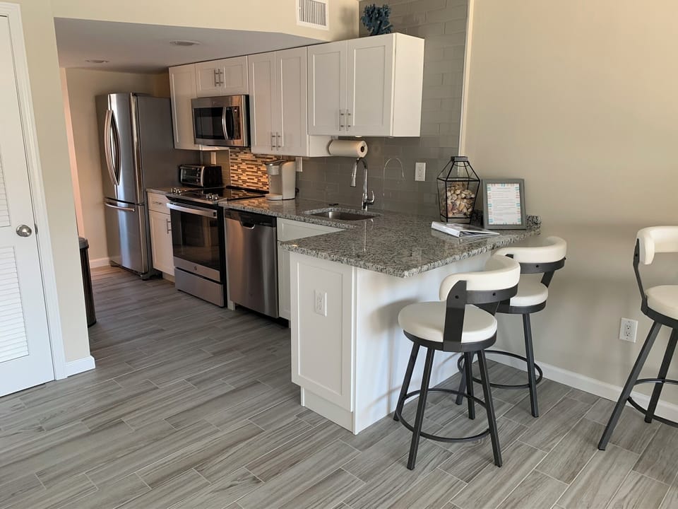 Large kitchen with counter seating and high top table with seating.