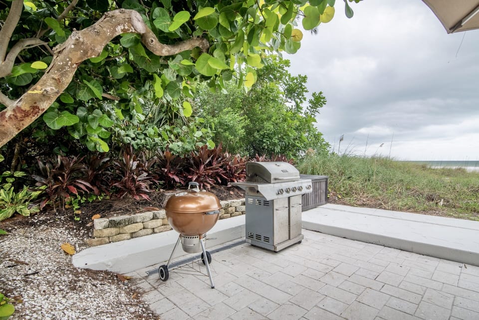Charcoal and gas BBQ grills on patio with gulf water views