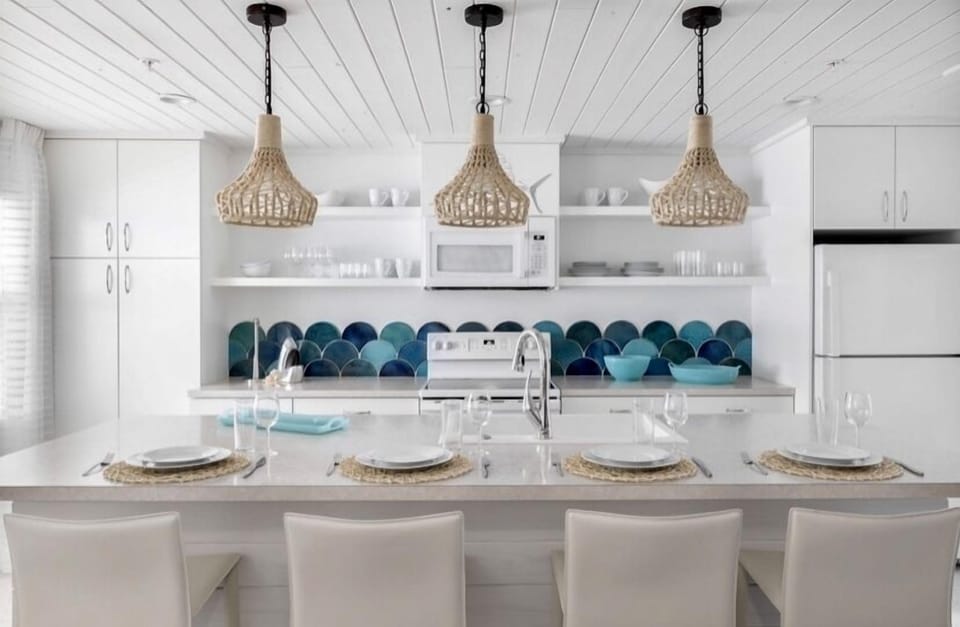 Customized watercolored, handmade clay tiles are the focal point of this white cottage kitchen