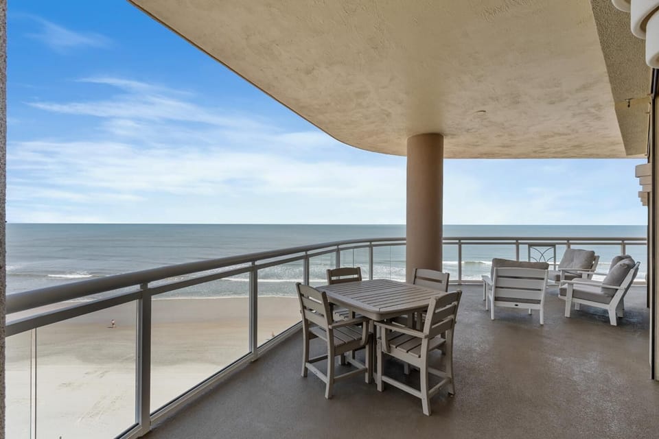Spacious oceanfront balcony with panoramic sea views and cozy seating