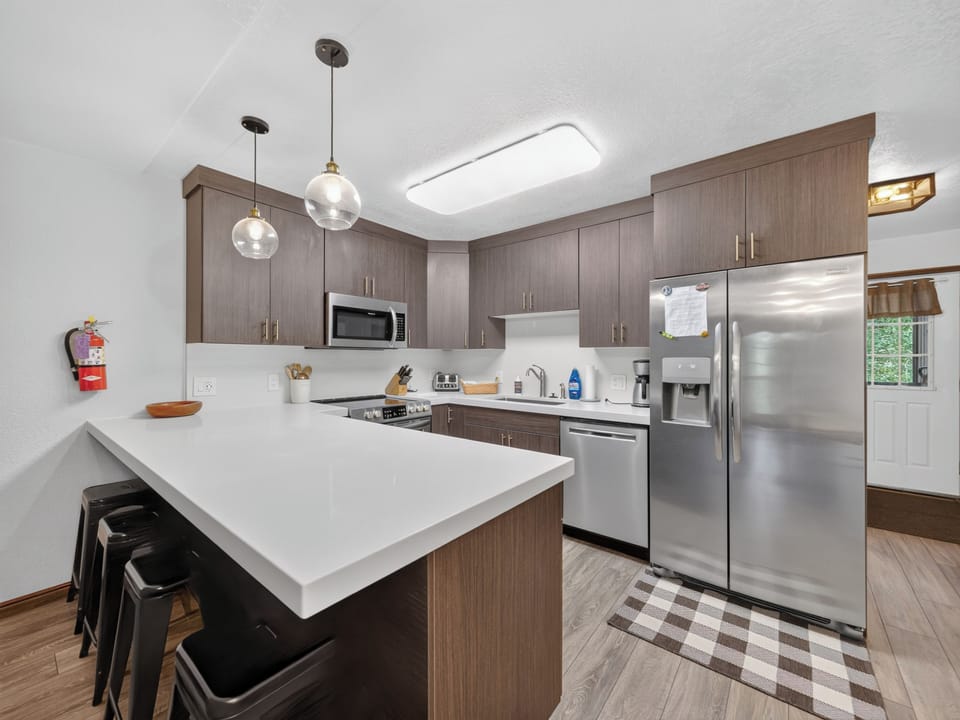 Your spacious chef's kitchen awaits with gleaming stainless appliances, abundant counter space, and a welcoming island perfect for gathering over morning coffee or preparing family meals together.
