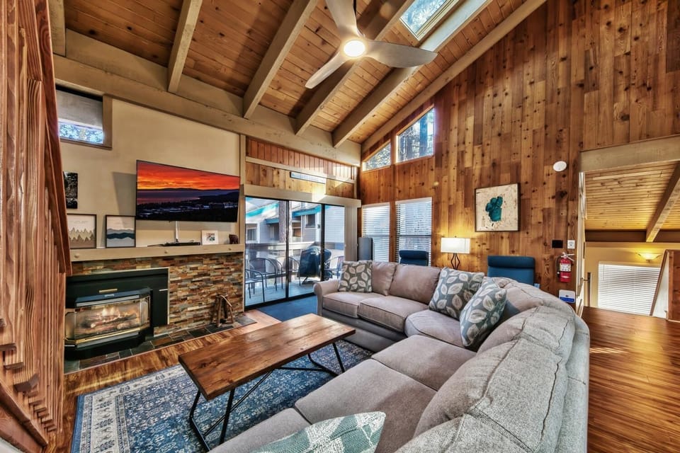 Cozy up in this warm living space with soaring wood ceilings, a gas fireplace, and spacious sectional perfect for movie nights.
