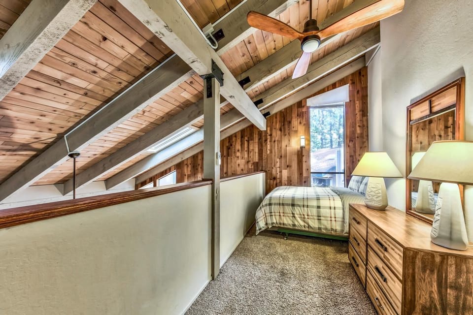 Your cozy loft bedroom features soaring wood ceilings, warm furnishings, and gentle lighting that creates the perfect mountain retreat atmosphere.