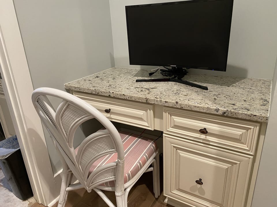 Built in desk with large monitor adjacent to laundry room on main level