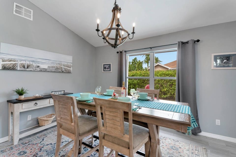 The dining room is located adjacent to the kitchen and offers a view of the pool area