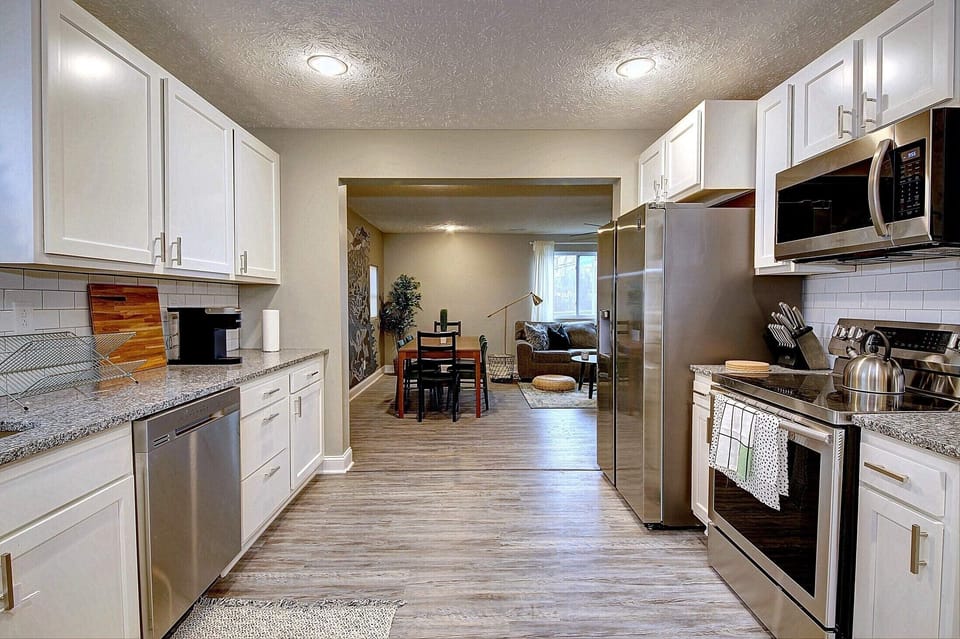 Spacious kitchen with granite counters, subway tile backsplash and appliances.