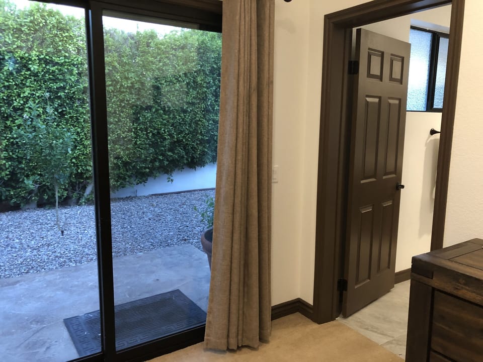 4th bedroom with sliding door to side-yard with fruit trees.