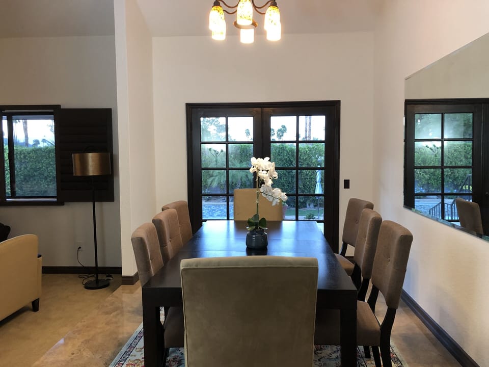 Dining room seats 8 and overlooks patio and pool through french doors.