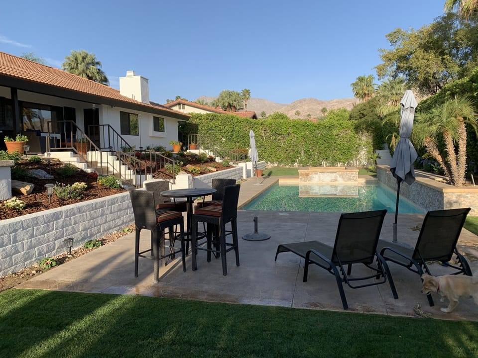 Bar height table and chairs and lounge chairs for relaxing by the pool.