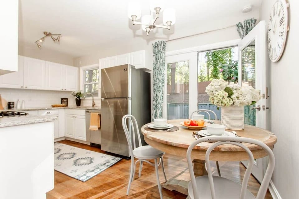 Cook, gather, and linger over meals in a full kitchen that opens beautifully into the dining area — stainless appliances, a dining table for the whole crew, and a large window framing your private backyard.
