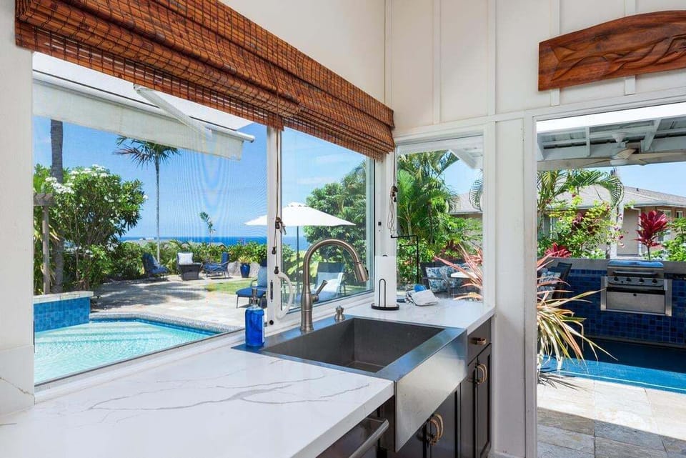 A beautifully designed kitchen with natural wood countertops, large island, high-back stools, and quality appliances.