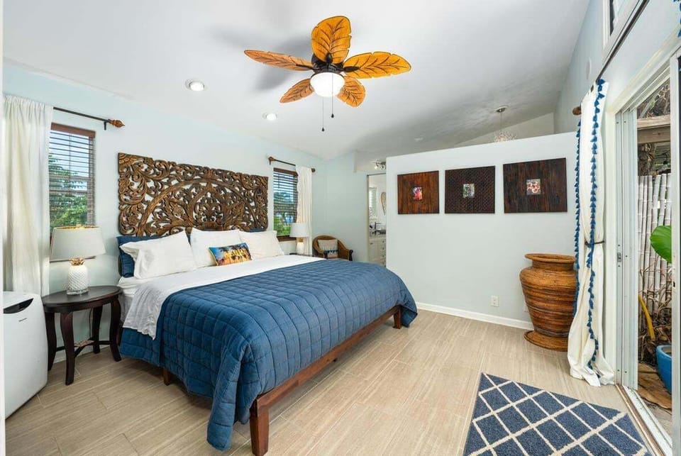 A serene primary suite offering a queen bed, large walk-in closet, and direct access for easy poolside mornings.