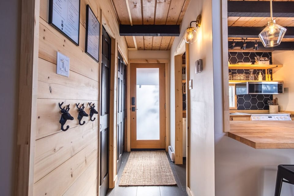 Entryway with kitchen on one side and entry closet & full bathroom on other side