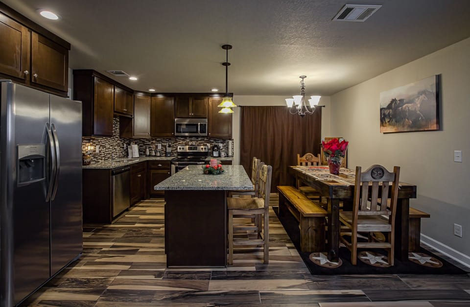 Fully furnished kitchen.  Island seating, dining table with bench seating. 