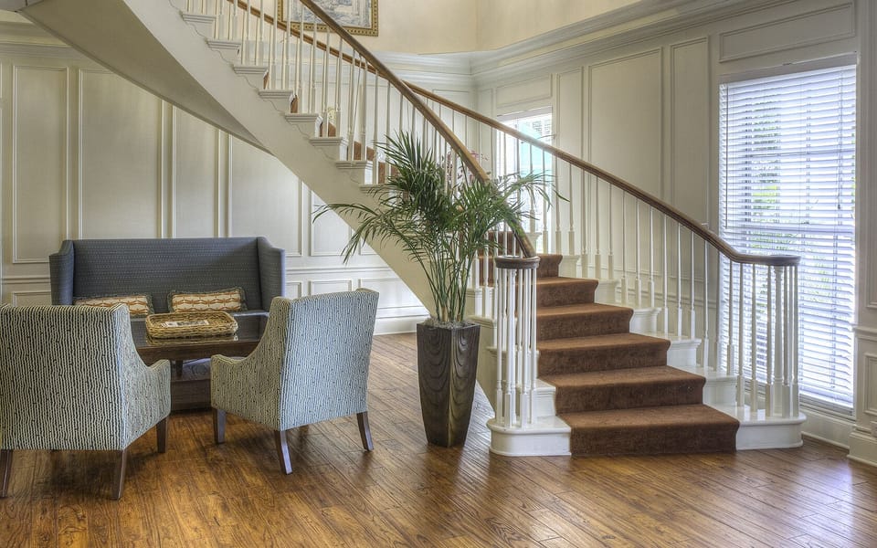 Settle into quiet conversation beneath the sweeping staircase.
