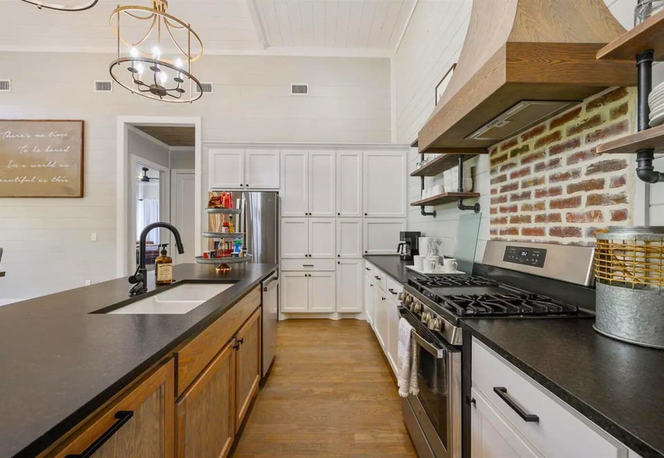 Master the art of rustic chic in this charming kitchen, where modern appliances meet classic brick accents