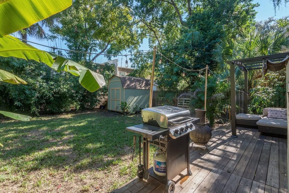Backyard Oasis: Enjoy outdoor dining with a grill and lush greenery for a tranquil retreat!