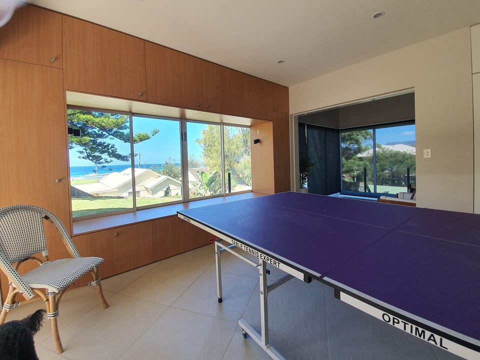 games room downstairs with TV and ping pong table