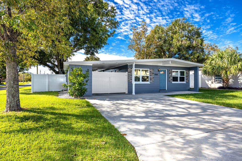 Charming Exterior: Enjoy sunny Florida days in this inviting home with lush greenery and a welcoming vibe!