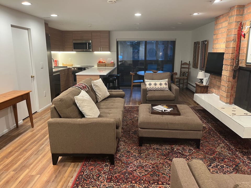 Open floor plan living, dining, kitchen area, with patio and gas grill.