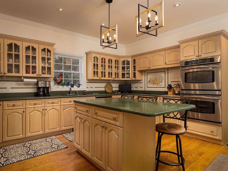 Kitchen with two ovens, electric cooktop, TV, microwave and small appliances