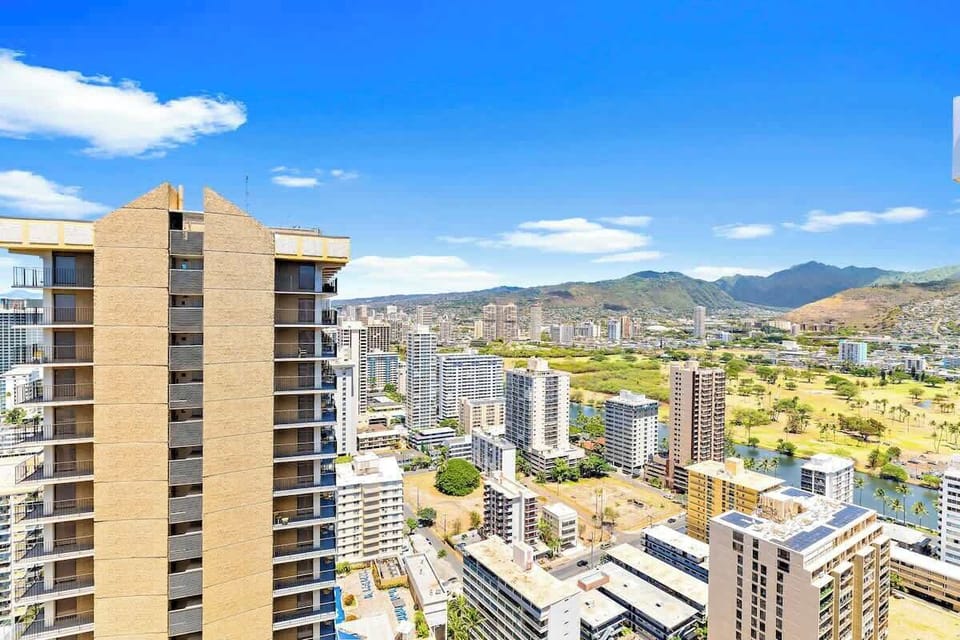 Cityscape view from a high-rise building with mountains in the background.