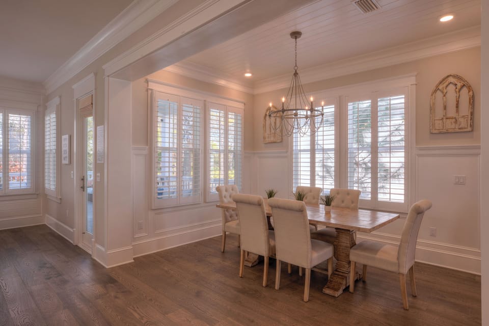 Dining room highlighting the tray ceiling and white plantation shutters.