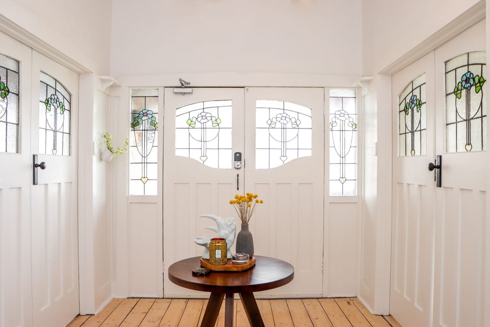 LIGHT FILLED ENTRY WITH ORIGINAL STAINED GLASS DOORS.