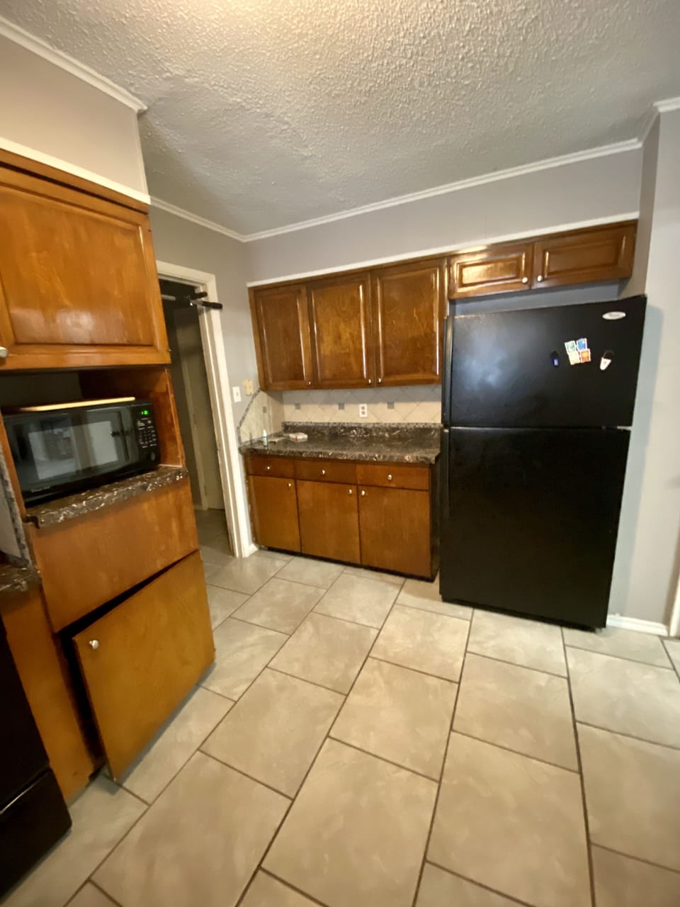 Fridge and storage in kitchen next to pantry.