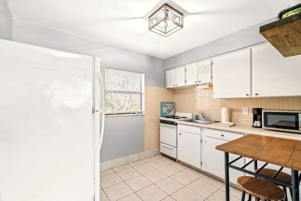 Boutique Beach Retreat Treasure Island full kitchen, stove refrigerator, freezer, microwave, coffee maker, kitchen utensils and flatware kitchen table