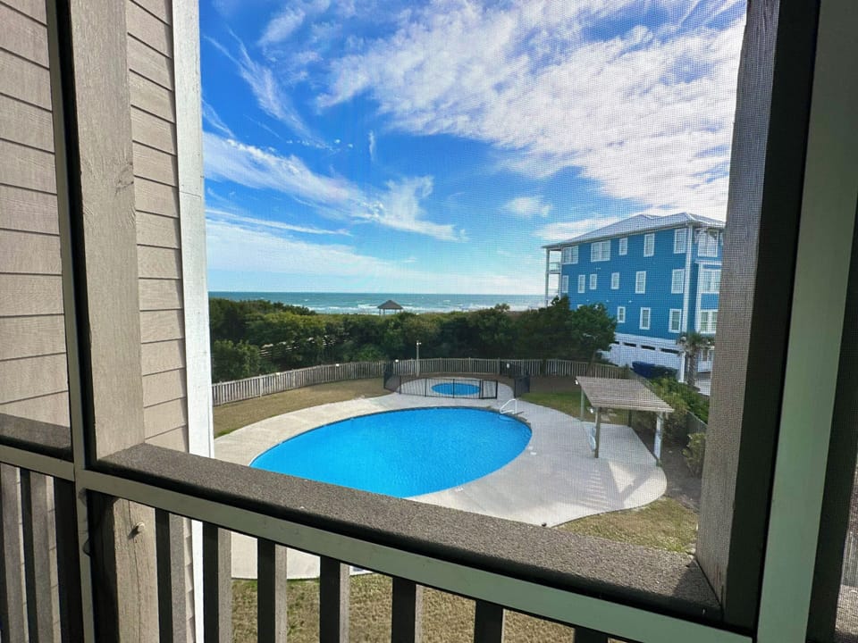 Screened in porch/balcony with view of pools