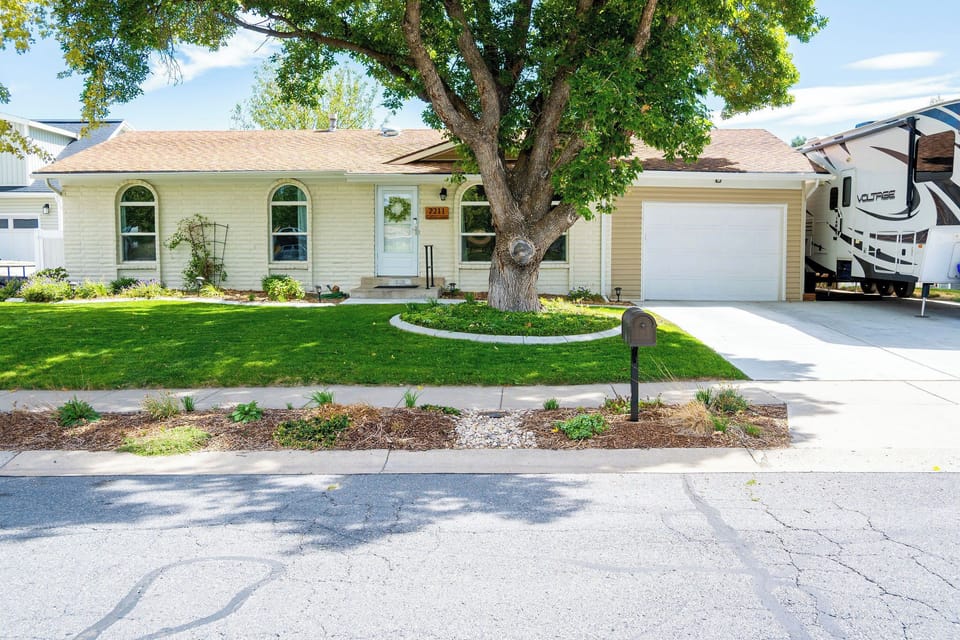 Front of house with beautiful landscaping, garage parking, and driveway parking