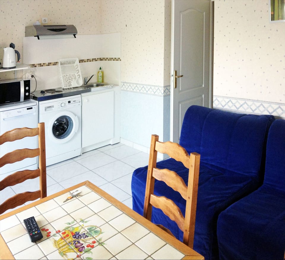 The living room, dining table, kitchen area and two single sofa beds