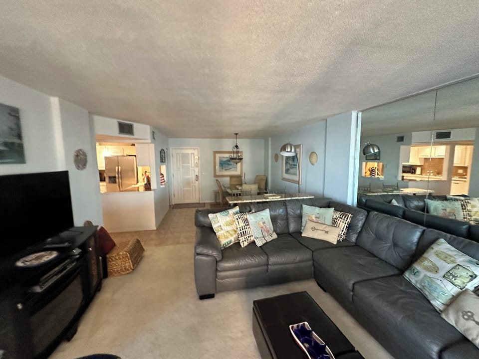 Spacious family room with a leather sectional couch. Open floor plan