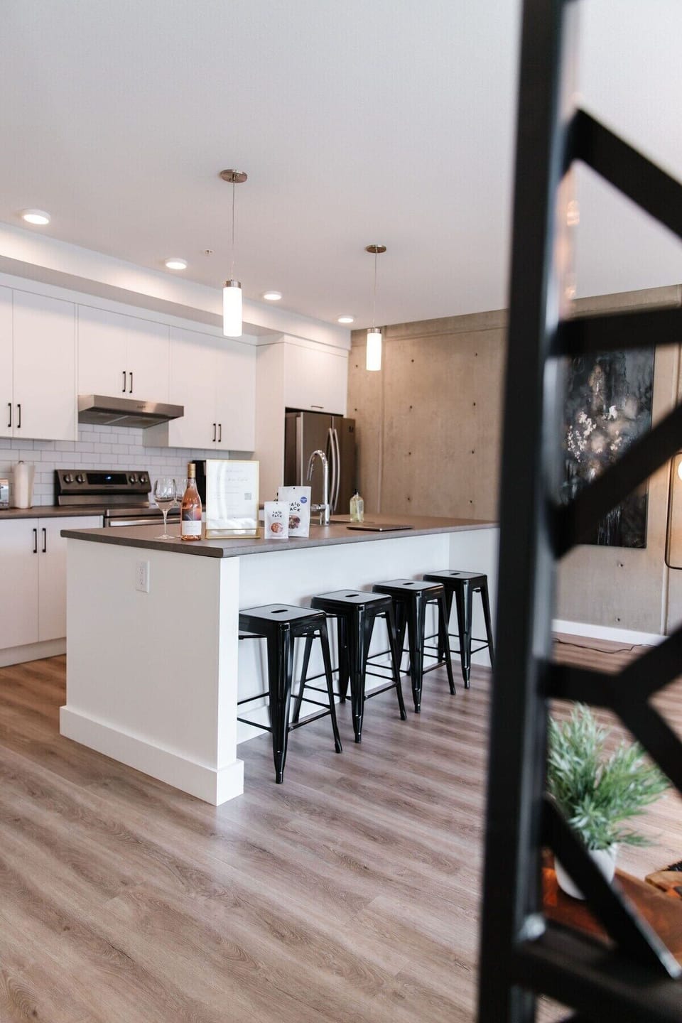 Enjoy breakfast at the spacious island, with sleek black stools inviting you to linger. The stainless steel fridge keeps essentials handy, while the warm wood floor adds a cozy touch.