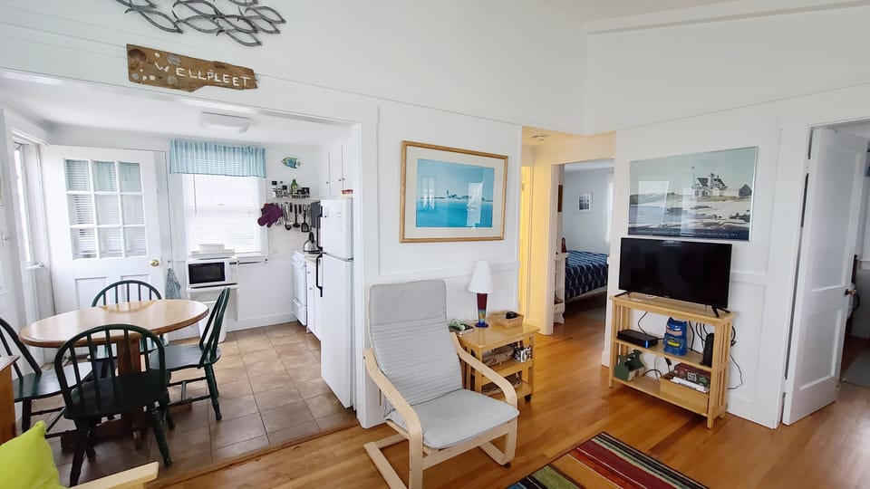 Living room with vaulted ceiling opens to kitchen