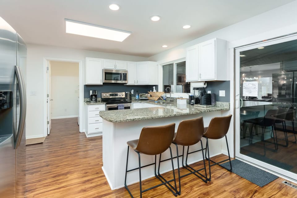 The kitchen includes breakfast bar seating  & connects to the dining & living rm