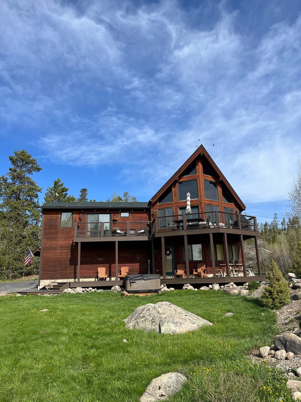 Exterior of the home showing hot tub and two decks and large lot.