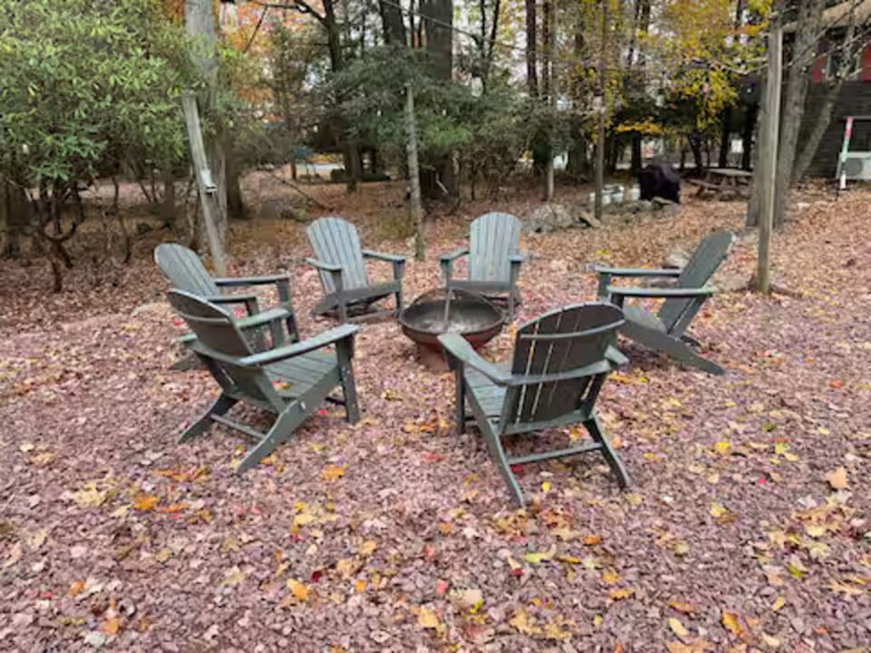 Woodland fire pit with Adirondack chairs—ideal for s’mores under the stars