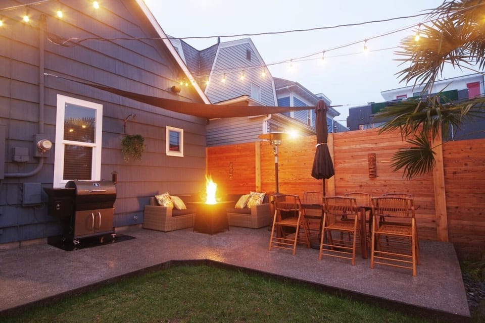 Big outdoor patio area with palm tree, outdoor heater, and fire pit