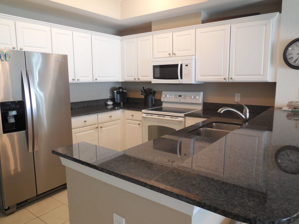 Well equipped kitchen with granite countertops.
