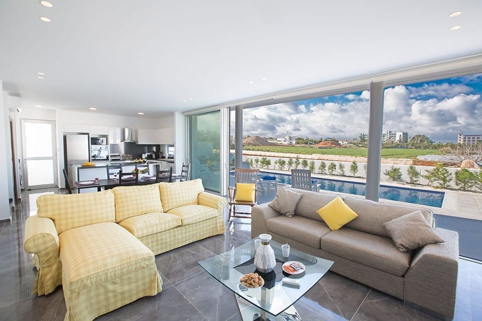Living room with comfortable sofas and large patio doors leading to the garden