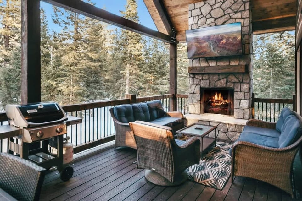Covered deck with outdoor fireplace and private pine forest views