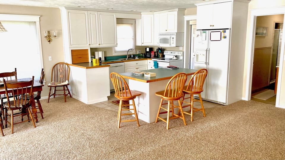 kitchen with dishes glasses , linens, coffee maker.